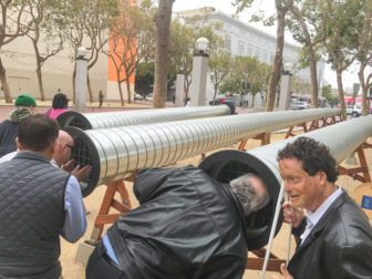 LightHouse staff peer down echo tubes during a guided tour of Exploratorium’s “Sound Commons” exhibition.