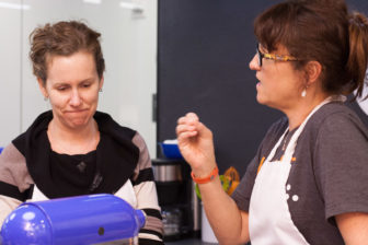 Sydney Ferrario shows a student how to use an egg beater.