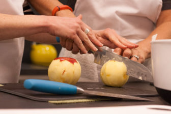 Sydney Ferrario shows a student, Jane Fowler, how to cut an apple.
