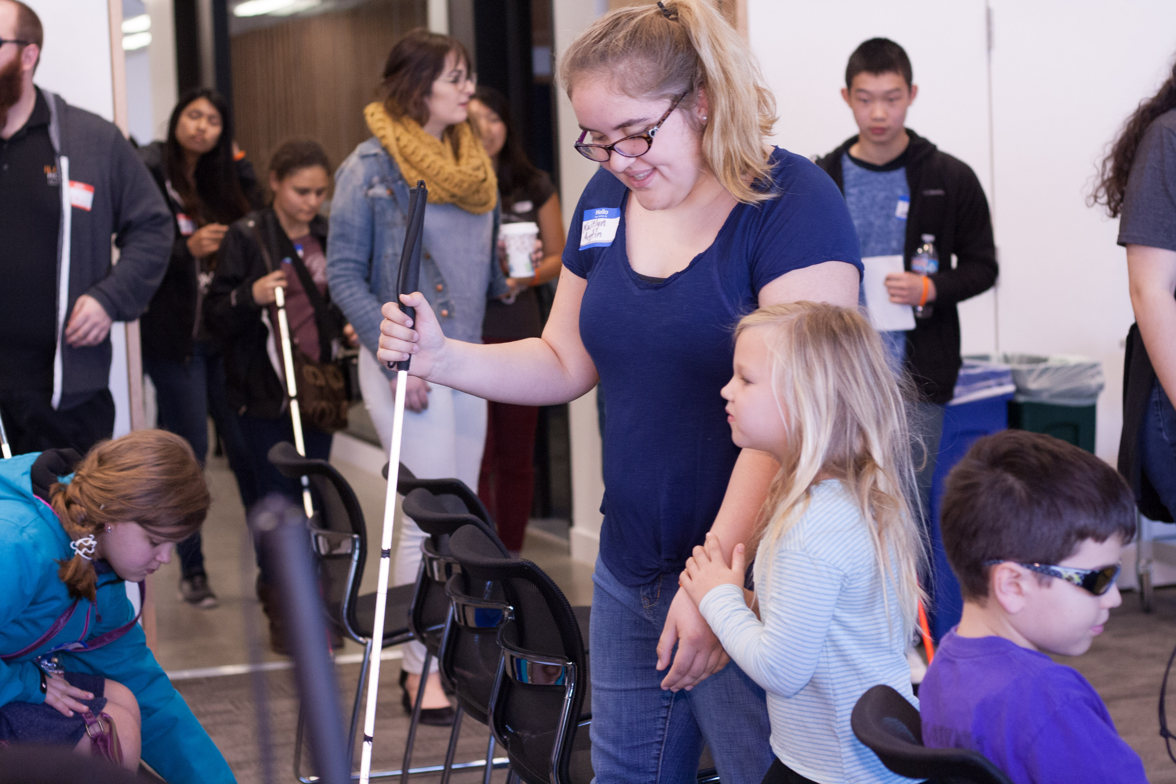 Competitor Kaitlyn Austin holds her little sister's hand and leads her to her seat in the LightHouse multipurpose rooms.