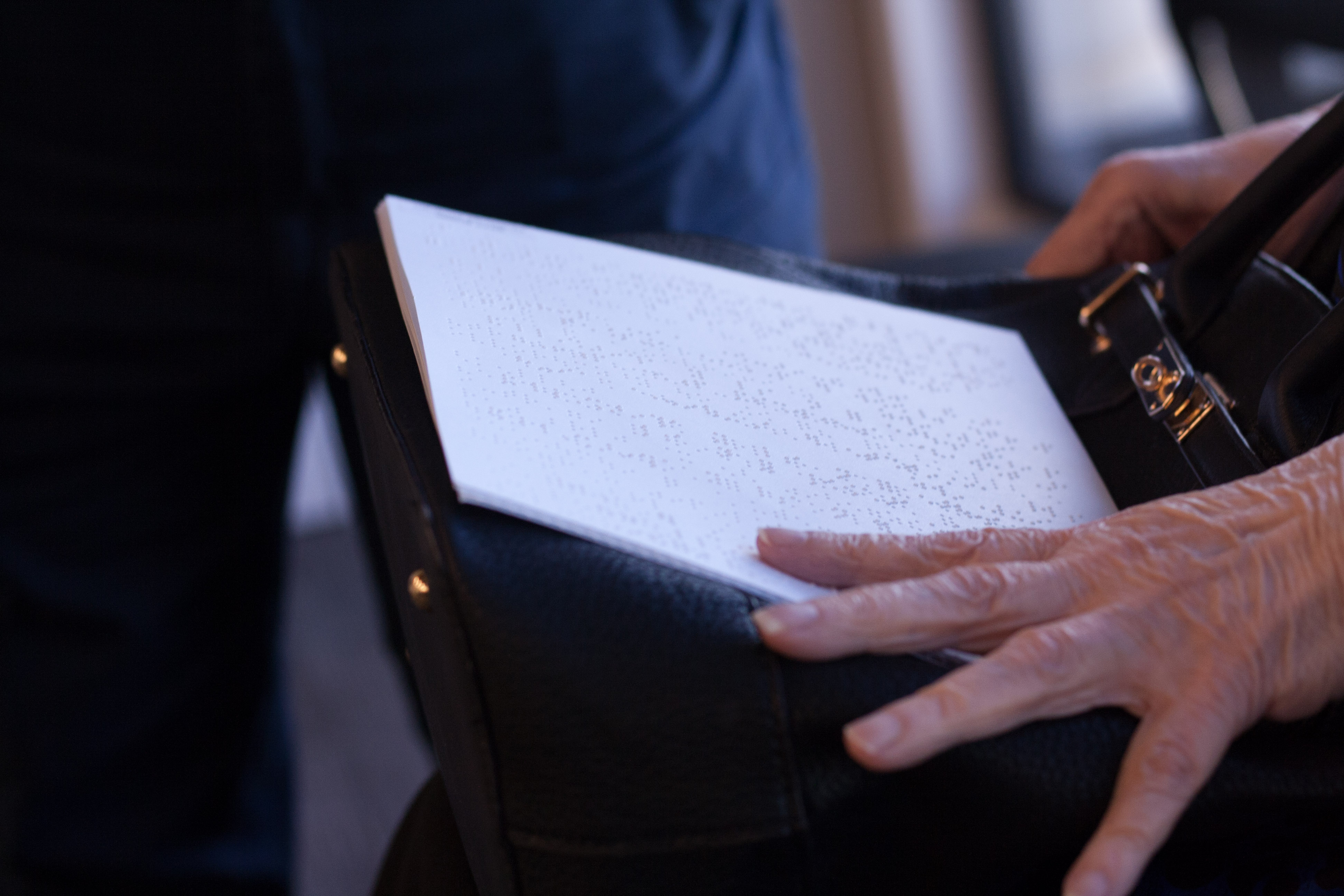 A close-up of Cathy Skivers' braille notes perched in her lap.