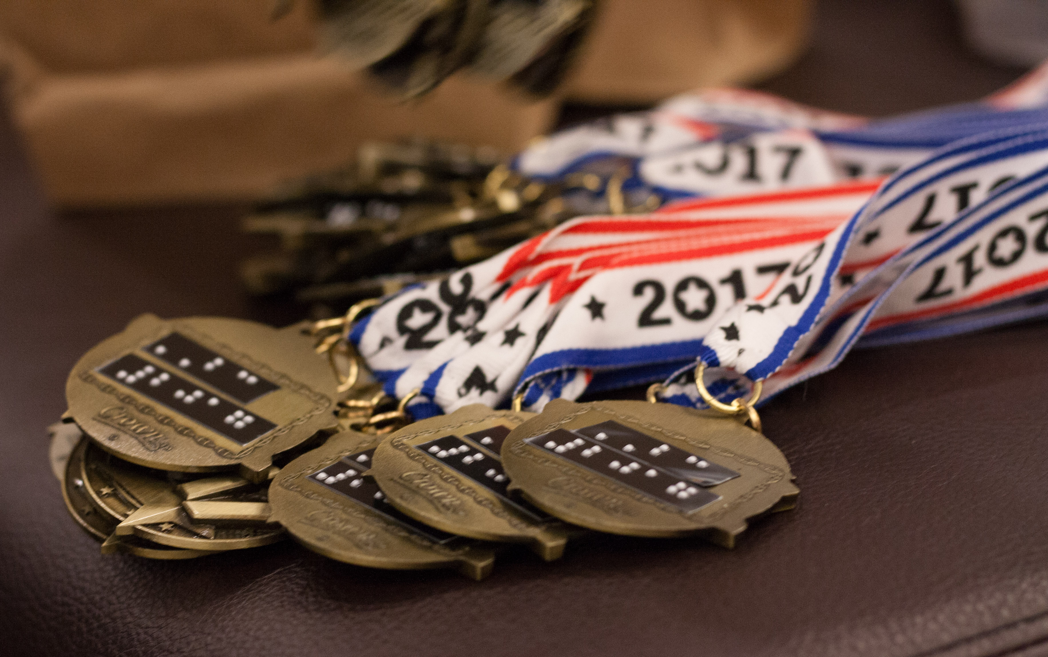 A closeup of the brailled Braille Challenge medals.
