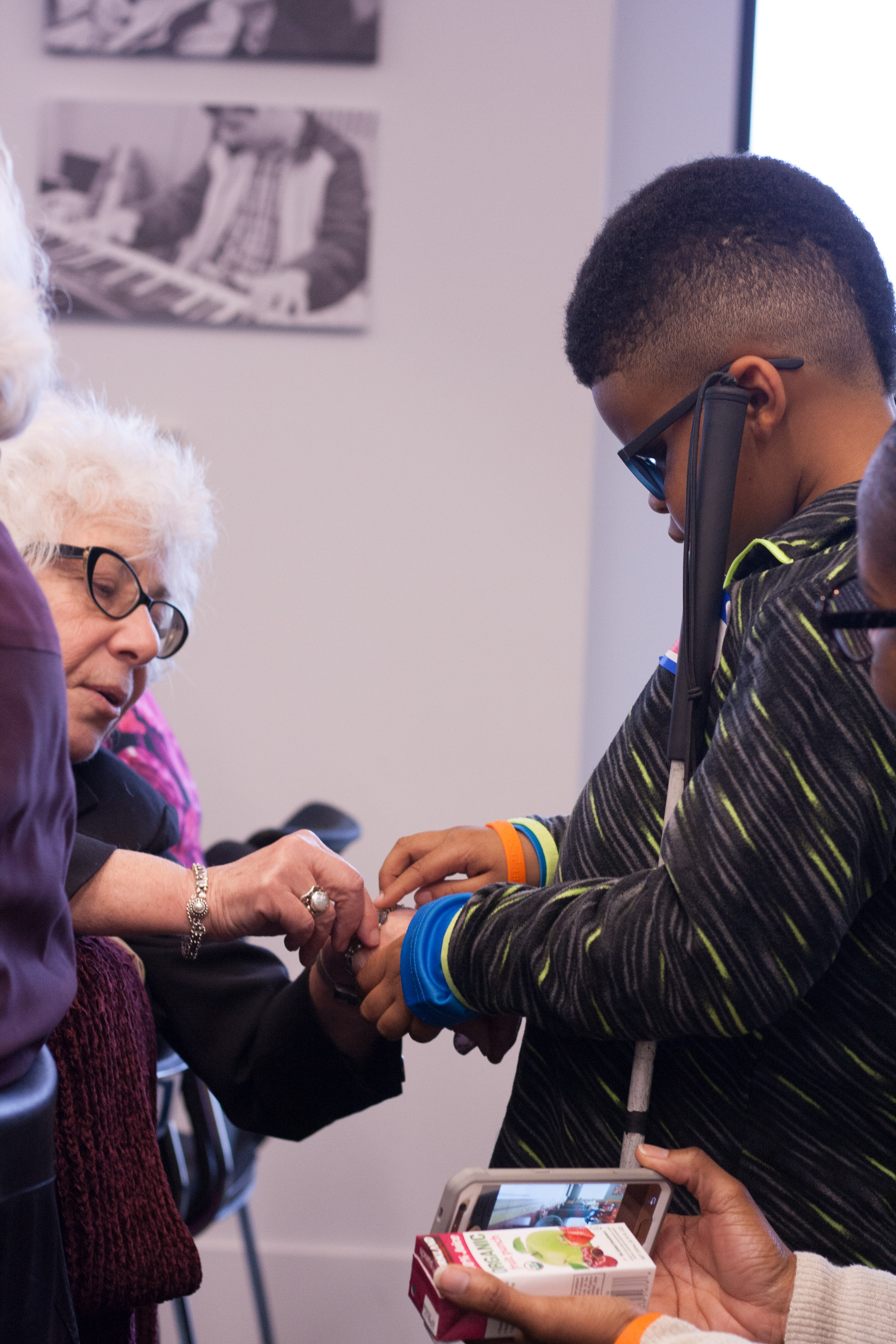 Apprentice competitor Miles feels proctor Donna's braille embossed bracelet. 