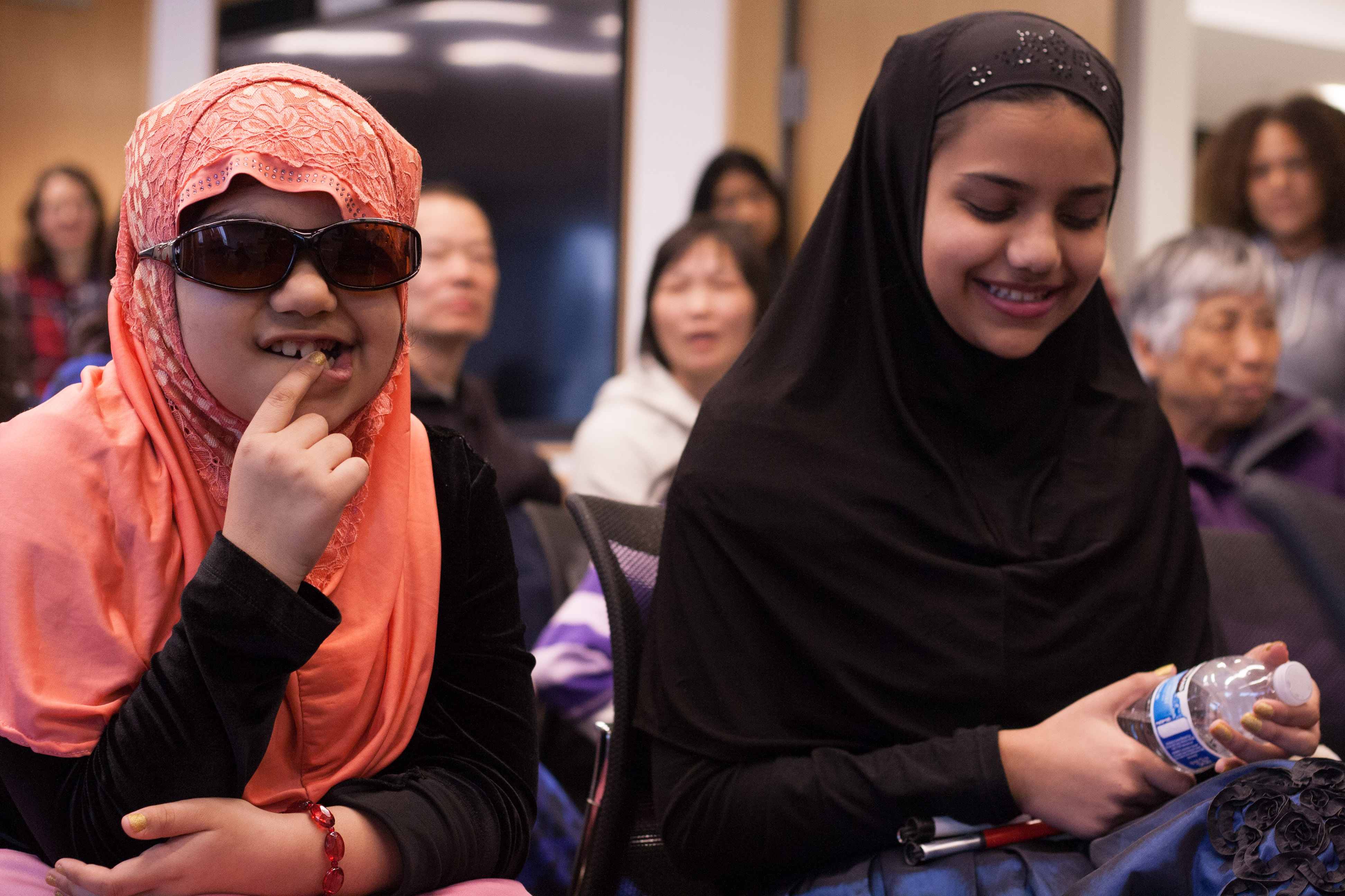 Sisters Maryam and Mariyah giggle while playing a game after the competition is over.