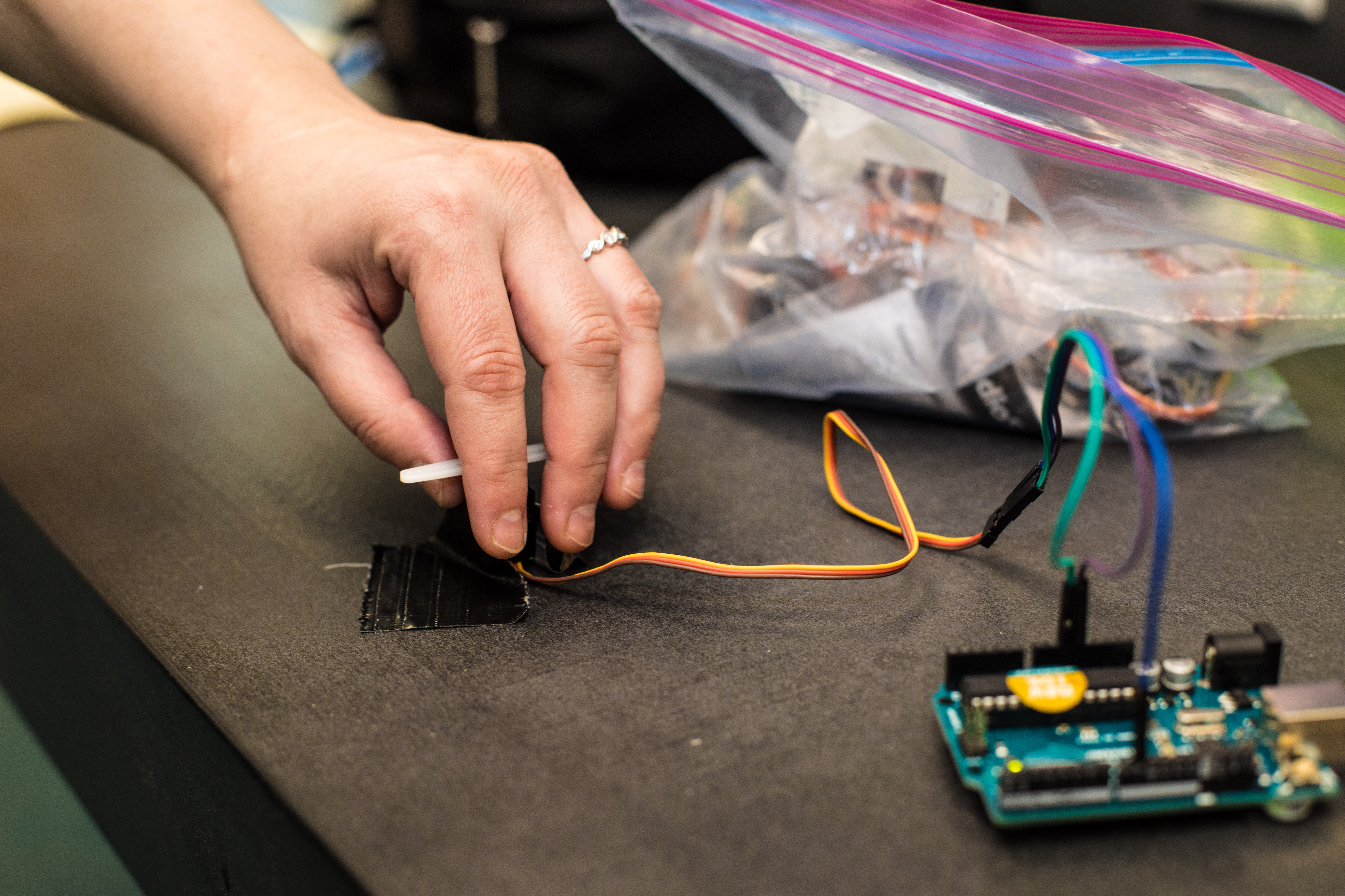 A closeup of a student's hand examining arduino electronics.