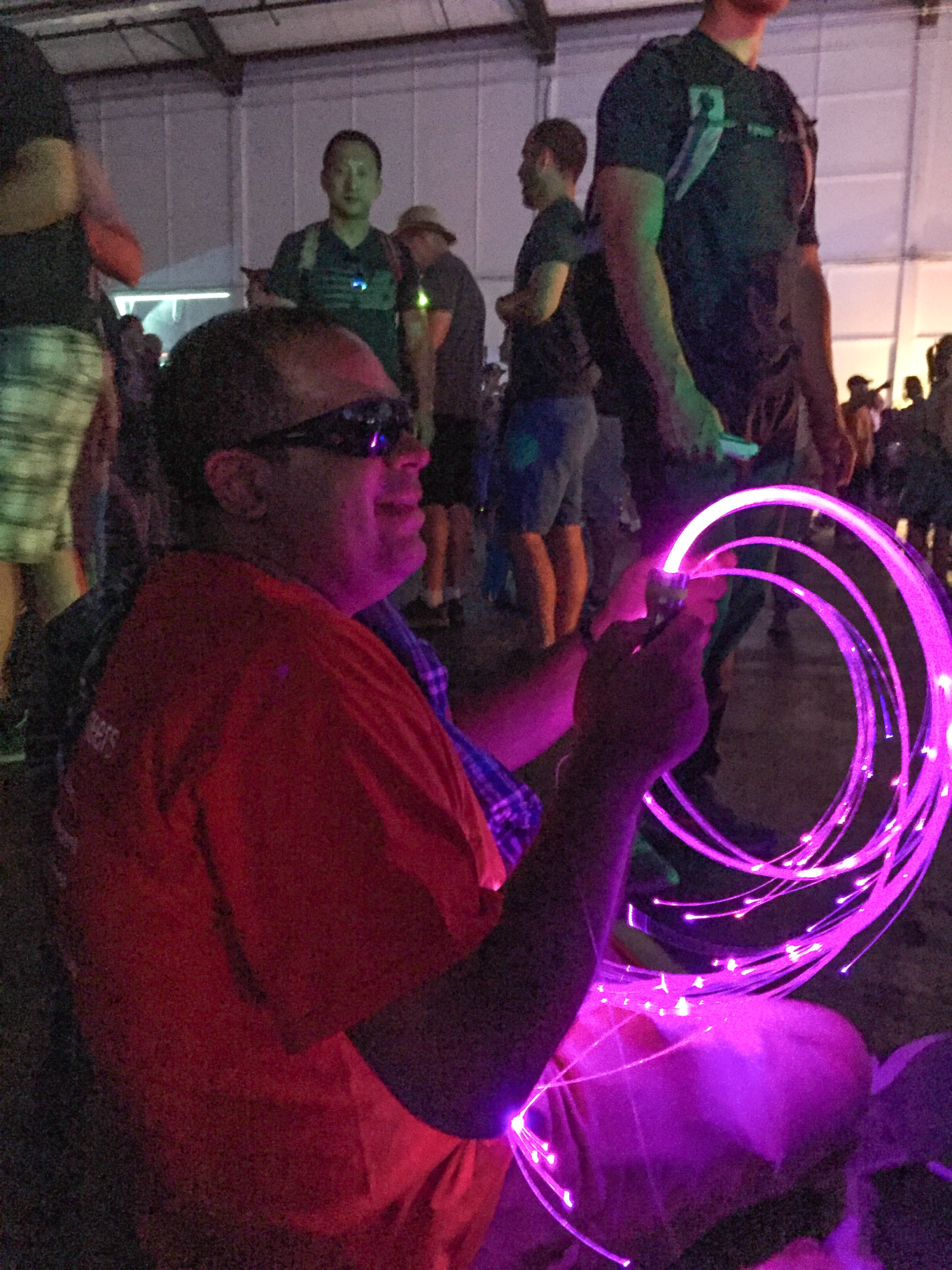 Youth Services Coordinator Richie Flores holds a spiral of purple rope lights in the Dark Room.
