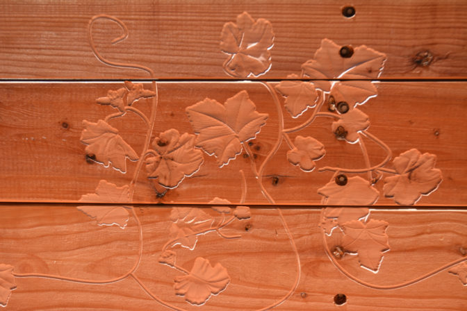 A detail ivy pattern carved into the back of one of the benches. 