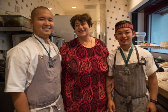 Penny smiles with One Market pastry chefs Mac and Jan, who she just presented with the pewter medals she will give to all her baking partners along her journey.