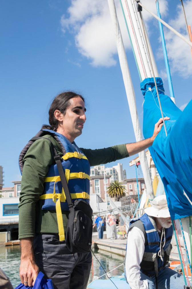 Ahmet stands up in the boat while preparing to set out to McCovey Cove.