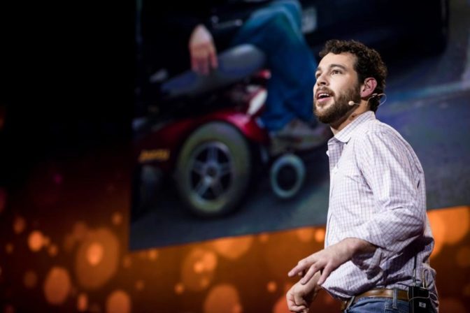 Reid Davenport speaks onstage to an audience. 