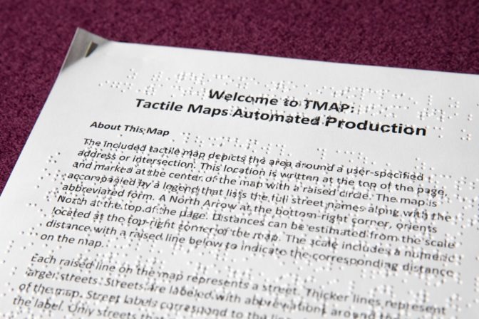 A closeup of the large print and brailled tactile maps explainer sheet, included in the package.