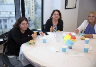 Kayla, her mother and a friend enjoying dinner seated at the table