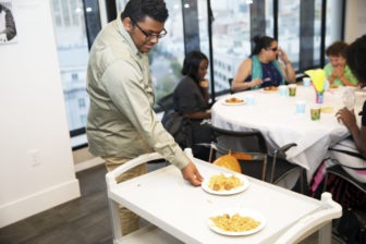 Jose serves pasta to a table of guests
