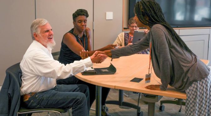 A YES student shakes hand with a mentor.