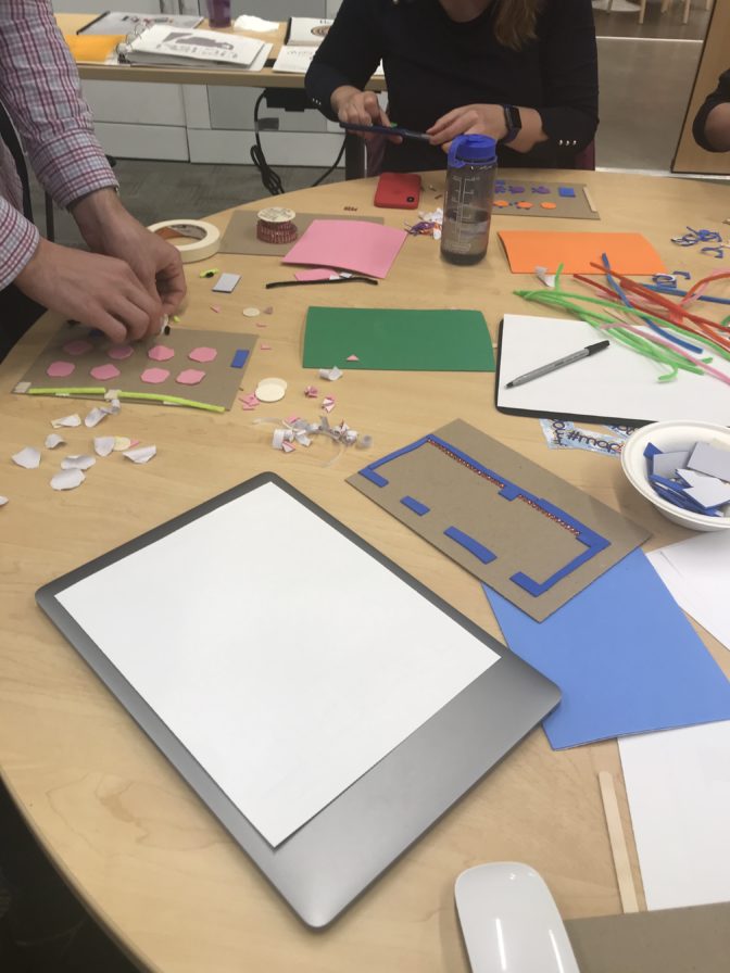 A starting challenge for the workshop was to create a tactile layout of the room. Here, designers are using circular foam cut-outs to map the tables in the event space at LightHouse.
