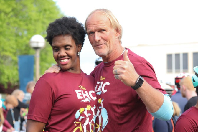 Ben and Bobbi smile and give a thumbs up, outdoors at the Cycle for Sight.