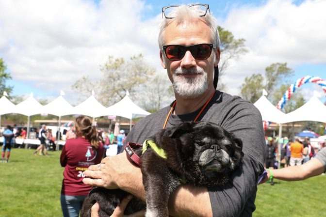 LightHouse Development Officer Paul Blaney smiles with his pet pug Seymour.