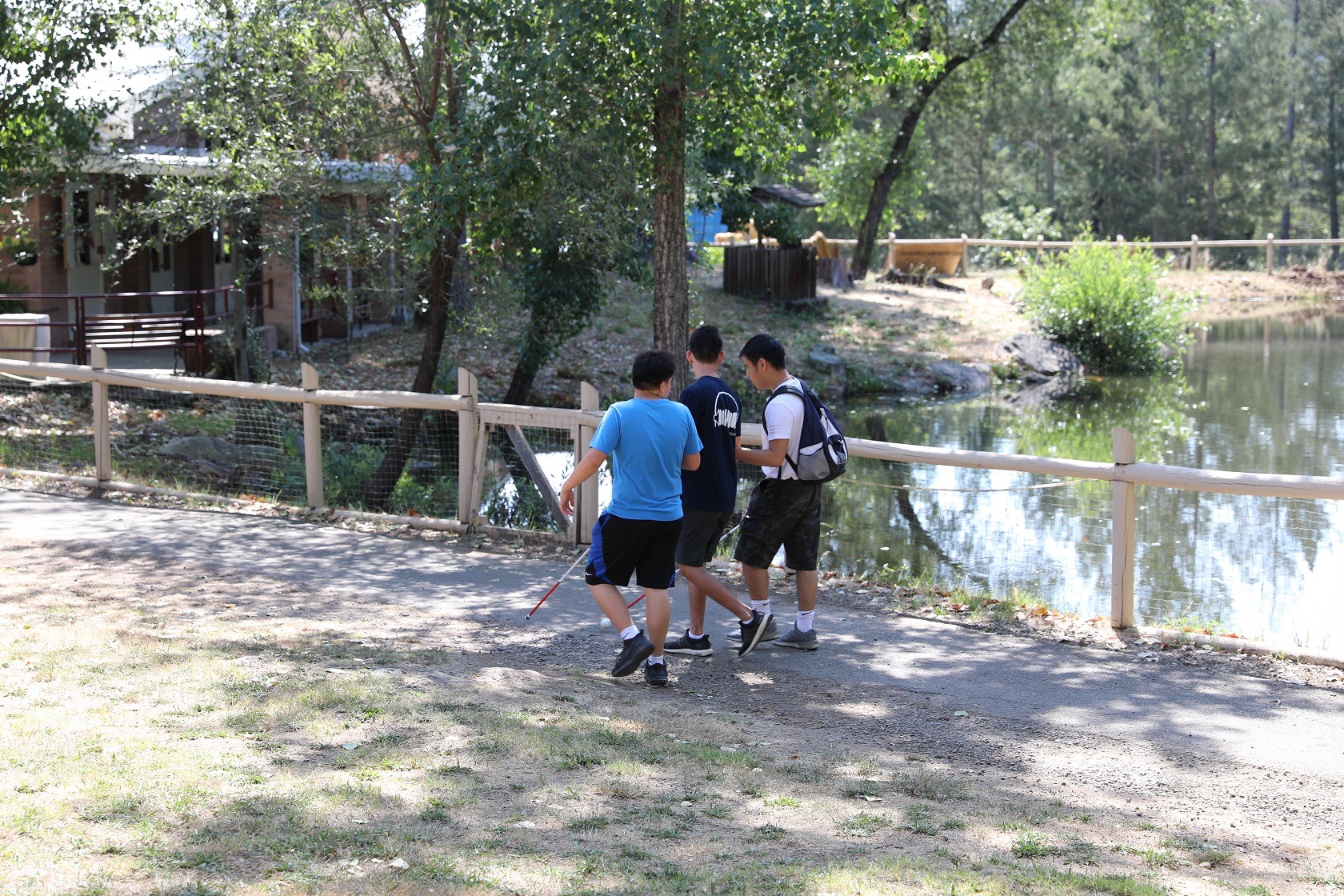 Campers with white canes walk in front of peaceful Lake Lokoya.