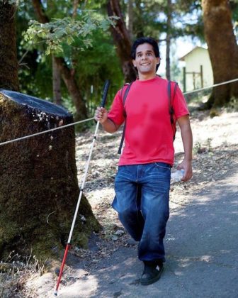 Sergio with his white cane hiking down Cardiac Hill at Enchanted Hills Camp