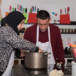 Estudiantes del programa YES en la cocina de LightHouse aprendiendo a cocinar.
