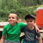 two kids sit on a bench and smile at EHC