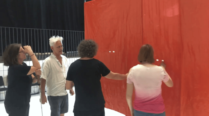 Jess Curtis explains the design of a show curtain during a haptic access tour