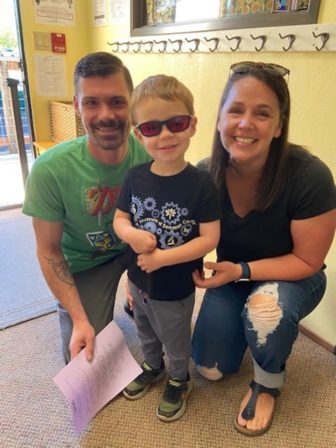 Dad, Little Learner and Amy kneel for a photo. Little Learner wears sunglasses