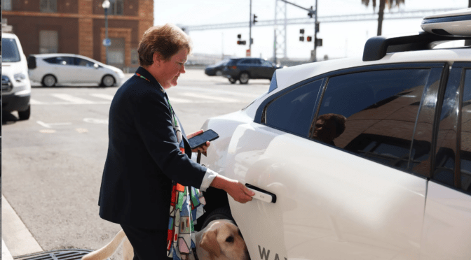 LightHouse CEO Sharon G. and guide dog Pilot getting into an autonomous vehicle