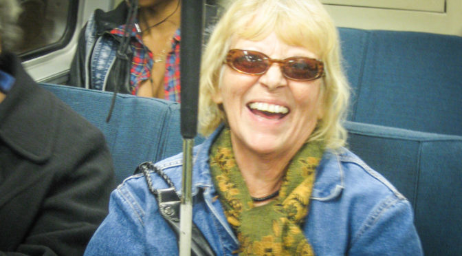 woman with cane smiling on subway
