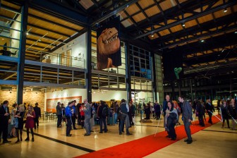 dozens of blind people stand in the atrium of Pixar Animation Studios