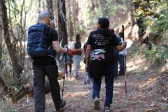 Teenage campers, some holding white canes, make their way through the woods of Enchanted Hills Camp.