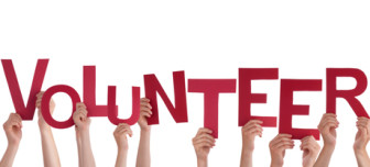 hands holding red letters that spell volunteer